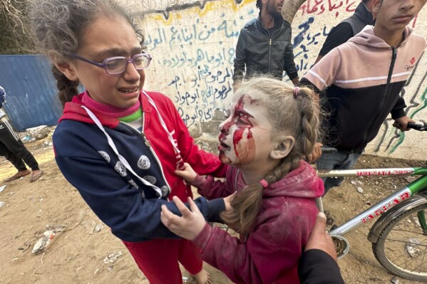 Hulp aan een gewond Palestijns meisje na een Israëlische aanval op Al-Zawaida in de centrale Gazastrook, donderdag 28 december 2023. (AP Photo/Mohammed Asad)