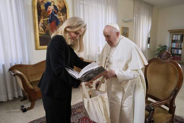 Associated Press correspondent Nicole Winfield shows Pope Francis an Associated Press book at the Vatican, on Jan. 24, 2023. (AP Photo/Andrew Medichini)
