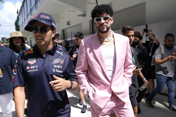 FILE - Red Bull driver Sergio Perez, of Mexico, left, walks with Puerto Rican reggaeton musician Bad Bunny before a Formula One Miami Grand Prix auto race at Miami International Autodrome in Miami Gardens, Fla., on May 8, 2022. As the sport grows in popularity, race weekends are transforming into mini music festivals with A-list talent performing after the day's event. (AP Photo/Lynne Sladky, File)