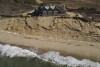 A home sits atop of a sandy bluff overlooking a beach in Wellfleet, Mass., Monday, Jan. 27, 2025. (AP Photo/Andre Muggiati)