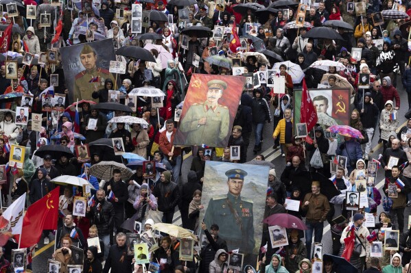 FILE - People attend the Immortal Regiment march through the main street toward Red Square marking the 77th anniversary of the end of World War II, in Moscow, Russia, Monday, May 9, 2022. In Russia, history has long become a propaganda tool used to advance the Kremlin's political goals. In an effort to rally people around the flag, the authorities have sought to magnify the country's past victories while glossing over the more sordid chapters of its history. (AP Photo/Denis Tyrin, File)