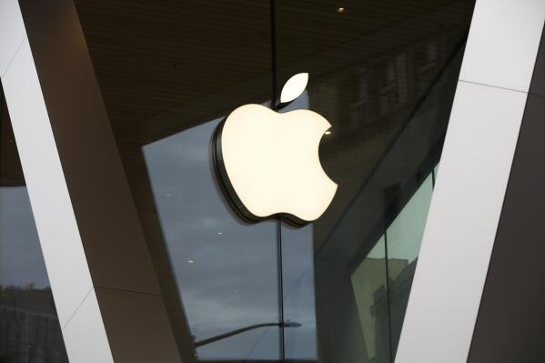 FILE - In this Saturday, March 14, 2020, file photo, an Apple logo adorns the facade of the downtown Brooklyn Apple store in New York. Apple shook off supply shortages that have curtailed production of iPhones and other popular devices to deliver its most profitable holiday season yet. The results announced Thursday, Jan. 27, 2022, for the final three months of 2021 help illustrate why Apple is looking even stronger at the tail end of the pandemic than when the crisis began two years ago. (AP Photo/Kathy Willens, File)