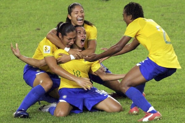 FILE - Brazil's Marta, center, celebrates her goal against the United States during a FIFA Women's World Cup semifinal soccer match in Hangzhou, China, Sept. 27, 2007. The six-time women's world player of the year plans to retire from the national team after 2024. (AP Photo/Greg Baker, File)