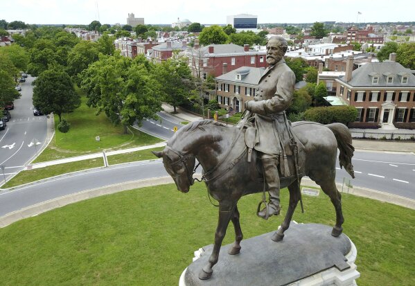 EDS NOTE: OBSCENITY - FILE - This Tuesday, June 27, 2017, file photo shows a statue of Confederate General Robert E. Lee in the middle of a traffic circle on Monument Avenue in Richmond, Va. Just a little over a month ago, the area around Richmond's iconic statue of Confederate Gen. Robert E. Lee was as quiet and sedate as the statue itself.  But since the May 25, 2020, police killing of George Floyd in Minneapolis, the area has been transformed into a bustling hub of activity for demonstrators protesting against police brutality and racism. (AP Photo/Steve Helber, File)