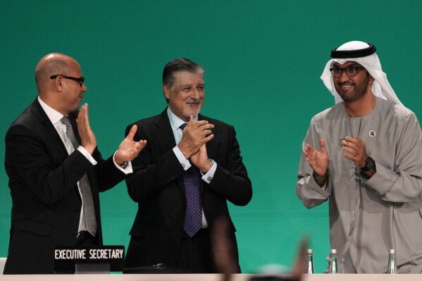 COP28 President Sultan al-Jaber, right, celebrates passing the global stocktake with United Nations Climate Chief Simon Stiell, left, and COP28 CEO Adnan Amin during a plenary session at the COP28 U.N. Climate Summit, Wednesday, Dec. 13, 2023, in Dubai, United Arab Emirates. (AP Photo/Kamran Jebreili)