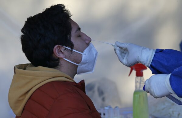 A man gets a nasal swab for a rapid COVID-19 test at a post set up in Mexico City, Saturday, Dec. 26, 2020. Mexico began applying the first dose of a COVID-19 vaccine on Dec. 24 produced by Pfizer and its German partner BioNTech as people are still getting tested for COVID-19. (AP Photo/Ginnette Riquelme)