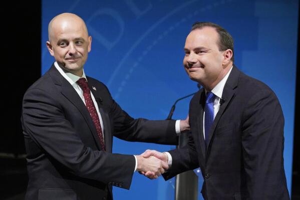 Utah Republican Sen. Mike Lee, right, and his independent challenger Evan McMullin shake hands before their televised debate, Monday, Oct. 17, 2022, in Orem, Utah, three weeks before Election Day. The debate will be the only time the candidates appear together in the lead-up to next month's midterm elections. (AP Photo/Rick Bowmer)