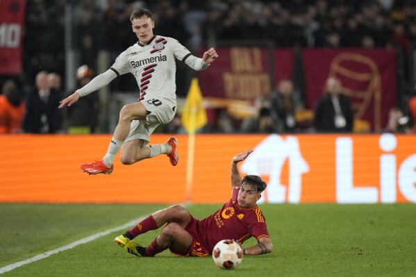 Leverkusen's Florian Wirtz, top, is challenged by Roma's Paulo Dybala during the Europa League semifinal first leg soccer match between Roma and Bayer Leverkusen at Rome's Olympic Stadium in Rome, Italy, Thursday, May 2, 2024. (AP Photo/Andrew Medichini)