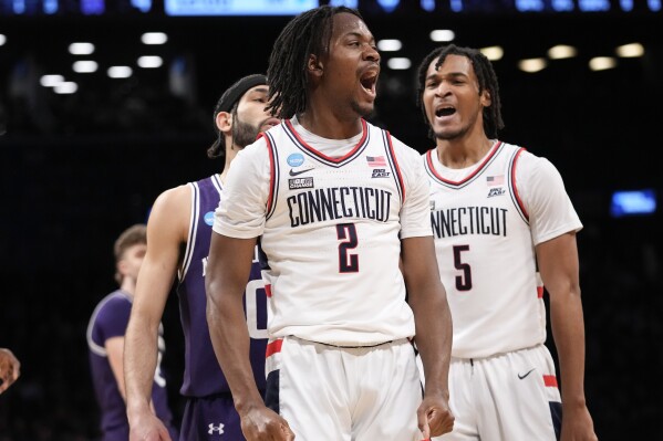 UConn guard Tristen Newton (2) and guard Stephon Castle (5) react during the first half of a second-round college basketball game against Northwestern in the NCAA Tournament, Sunday, March 24, 2024, in New York. (AP Photo/Mary Altaffer)