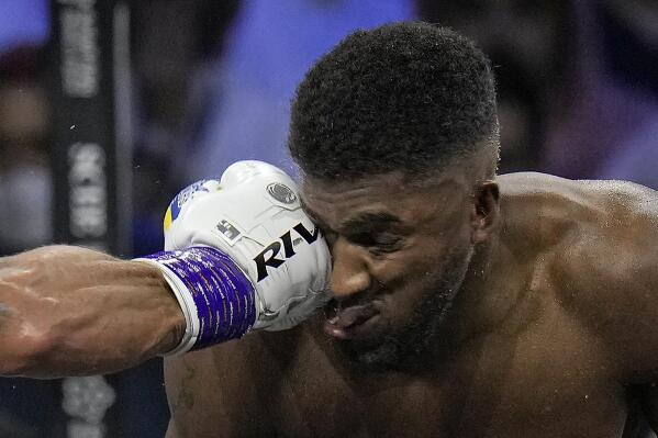 Britain's Anthony Joshua, right, takes a blow from Ukraine's Oleksandr Usyk during their world heavyweight title fight at King Abdullah Sports City in Jeddah, Saudi Arabia, Sunday, Aug. 21, 2022. (AP Photo/Hassan Ammar)