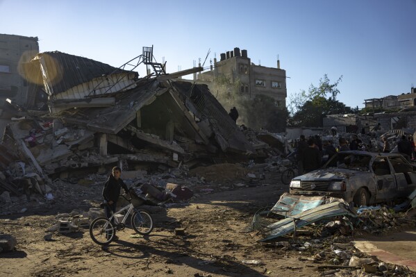 Palestinians search for bodies and survivors in the rubble of a residential building destroyed in an Israeli airstrike, in Rafah, southern Gaza Strip, Friday, Dec. 15, 2023. (AP Photo/Fatima Shbair)