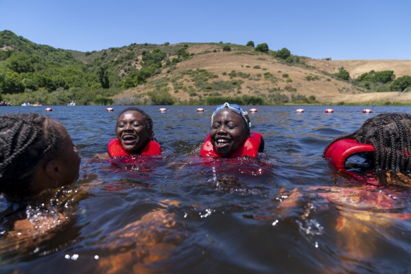Baileigh Davis, 11, of Houston, left, and Apiyo Bocast, 11, of Bozeman, Montana, laugh while swimming in the lake during Camp Be'chol Lashon, a Jewish sleepaway camp for children of color, Thursday, July 27, 2023, in Petaluma, Calif., at Walker Creek Ranch. Davis is the third generation of Black Jews in her family, while Bocast was adopted in Uganda by a Jewish woman. (AP Photo/Jacquelyn Martin)