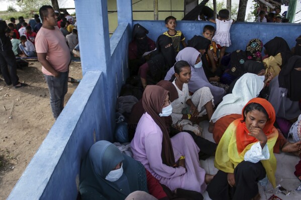 Newly-arrived ethnic Rohingya women, part of a group who was denied landing a few times by local residents, rest at a temporary shelter in Bireun, Aceh province, Indonesia Monday, Nov. 20, 2023. Almost 1,000 Rohingya Muslims from Myanmar have arrived by boat in Indonesia’s northernmost province of Aceh in the last six days, officials said Monday. The group finally landed in Bireuen district on Sunday morning. (AP Photo/Rafka Zaidan)