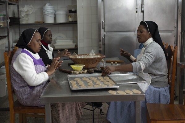 Pestiños, honey-coated pastries, are kneaded before frying by the cloistered nuns of the Clarisas convent in Carmona, Spain, on Thursday, Nov. 30, 2023. It's the fortnight before Christmas and all through the world's Catholic convents, nuns and monks are extra busy preparing the traditional delicacies they sell to a loyal fan base even in rapidly secularizing countries. (AP Photo/Laura Leon)