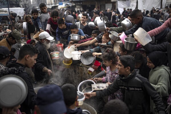 FILE - Palestinians line up for a free meal in Rafah, Gaza Strip, Thursday, Dec. 21, 2023. (AP Photo/Fatima Shbair, file)
