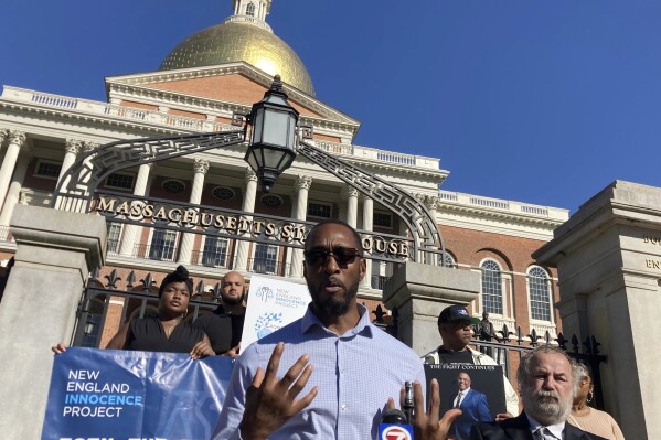Sean Ellis, 49, of Boston, who spent more than 20 years in prison for the 1993 killing of a police officer before his murder conviction was overturned, stands in front of the Massachusetts Statehouse Monday, Oct. 2, 2023, to call for an overhaul what activists describe as the state's inadequate compensation laws for those who have been unjustly imprisoned. To his right is Dennis Maher, 63, who also spent more than 19 years in prison before being exonerated. (AP Photo/Steve LeBlanc)