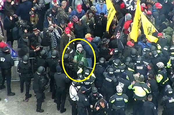 This image from U.S. Capitol Police video, contained and annotated in the Justice Department's statement of facts in support arrest warrant for David Joseph Gietzen, shows Gietzen, circled in yellow, pushing at a officer's shield at a police line on the West Front of the U.S. Capitol on Jan. 6, 2021, in Washington. The North Carolina man who became a fugitive after a federal jury convicted him of assaulting police officers during the U.S. Capitol riot has been sentenced to six years in prison. (Department of Justice via AP)