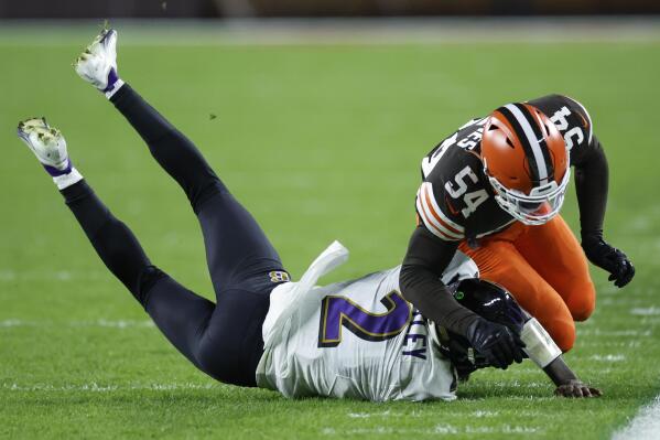 Cleveland Browns linebacker Deion Jones (54) tackles Baltimore Ravens quarterback Tyler Huntley during the second half of an NFL football game, Saturday, Dec. 17, 2022, in Cleveland. (AP Photo/Ron Schwane)