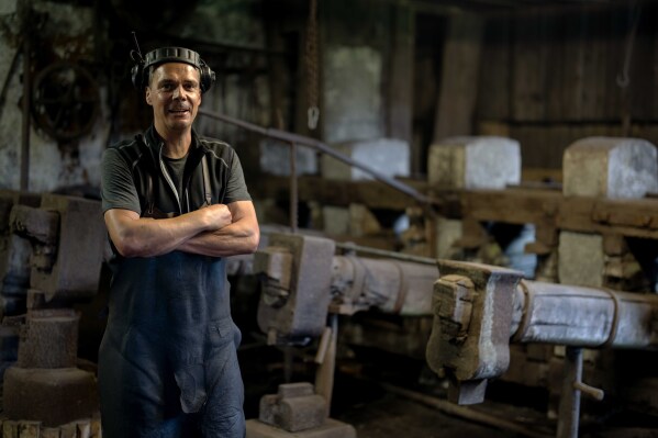 Hammersmith Andreas Rohrmoser poses for a photo in his hammer forge, in Bad Oberdorf, Germany, Monday, Sept. 18, 2023. Rohrmoser has been forging thousands of wrought-iron pans the old-fashioned way in his centuries-old hammer mill in the Bavarian village of Bad Oberdorf near the Austria border. (AP Photo/Matthias Schrader)