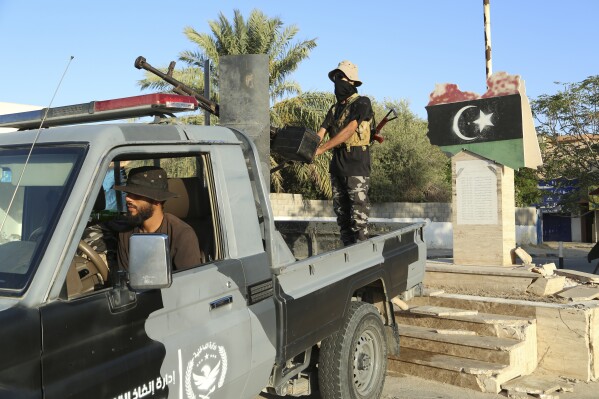 Libyan security forces stand guard in Tripoli, Libya, Tuesday, Aug. 16, 2023. Clashes between rival militias in Libya's capital killed a few dozen people and left residents trapped in their homes Tuesday, unable to escape the violence, medical authorities said. (AP Photo/Yousef Murad)