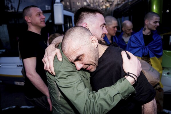 A Ukrainian soldier hugs his comrade after returning from captivity in a POW exchange in Ukraine, on Saturday, April. 19, 2025. (AP Photo/Evgeniy Maloletka)