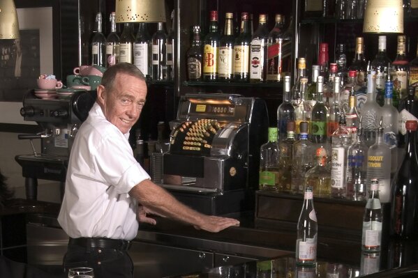 FILE - Joe Allen, proprietor of Joe Allen's restaurant poses behind the bar in New York on Nov. 10, 2005. Allen, whose Times Square-adjacent bistro which bears his name has been a decades-long draw...