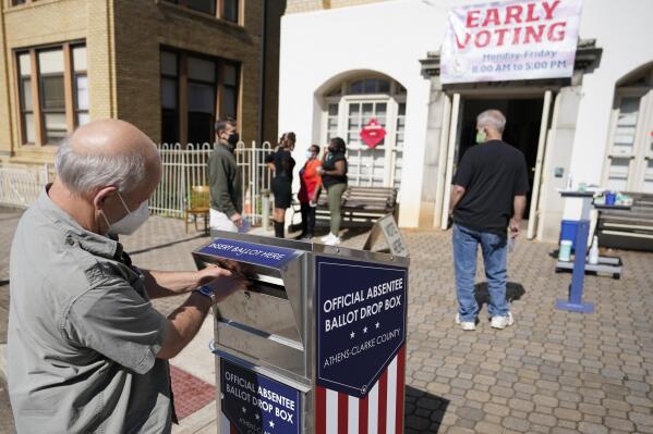 FILE - A voter submits a ballot in an official drop box during early voting in Athens, Ga., on Oct. 19, 2020. The widespread use of absentee ballot drop boxes during the 2020 election was largely trouble-free, contrary to claims made by former President Donald Trump and his Republican allies. An Associated Press survey of state election officials across the U.S. revealed no problems that could have affected the results, including from fraud, vandalism or theft. (AP Photo/John Bazemore, File)