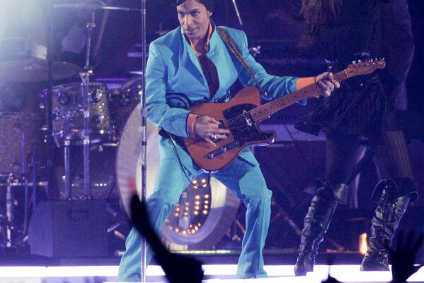FILE - Prince performs during the halftime show at the Super Bowl XLI NFL football game at Dolphin Stadium in Miami on Sunday, Feb. 4, 2007. When the Super Bowl halftime show was born, high school and college marching bands took center field. But over the years, the intermission during the NFL’s championship game has turned into one of sports’ biggest spectacles with superstar performances. (AP Photo/Mark J. Terrill, File)