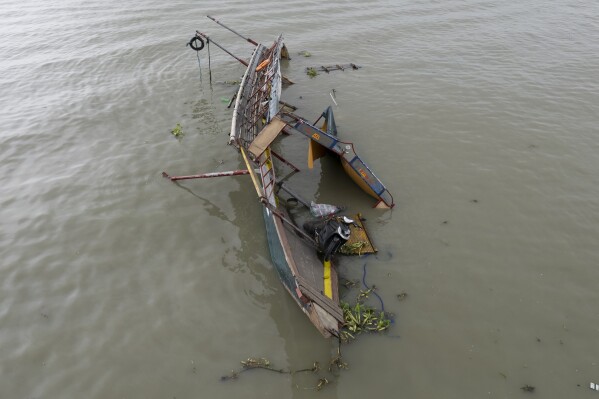 This photo taken by drone shows the remains of a passenger boat that capsized in Binangonan, Rizal province, Philippines on, Friday, July 28, 2023. The small Philippine ferry turned upside down when passengers suddenly crowded to one side in panic as fierce winds pummeled the wooden vessel, leaving several people dead while others were rescued, officials said Friday. (AP Photo/Aaron Favila)