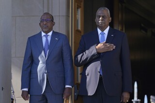 Defense Secretary Lloyd Austin, right, and Kenya's Defense Minister Aden Duale, left, listen during the National Anthem during a ceremony at the Pentagon in Washington, Wednesday, Feb. 7, 2024. (AP Photo/Susan Walsh)