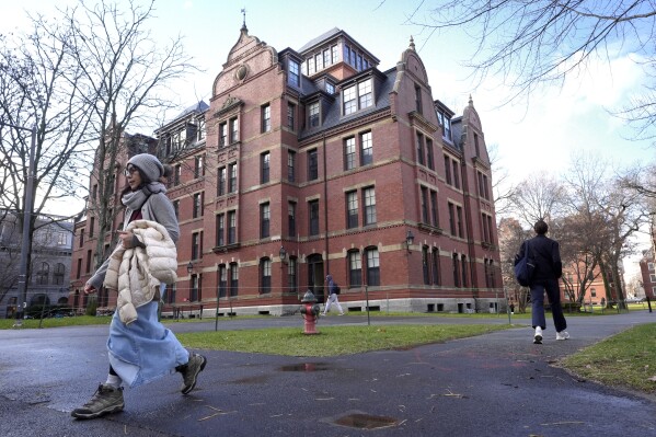 People walk between buildings, Dec. 17, 2024, on the campus of Harvard University in Cambridge, Mass. (AP Photo/Steven Senne, File)