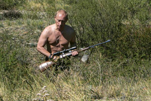 In this photo released on Saturday, Oct. 30, 2010, then-Russian Prime Minister Vladimir Putin carries a hunting rifle during his trip in Ubsunur Hollow in the Siberian region of Tuva, on the border with Mongolia. Putin sent Russian forces into Ukraine on Feb. 24, 2022, and appears determined to prevail -- ruthlessly and at all costs. (Dmitry Astakhov, Sputnik, Government Pool Photo via AP, File)