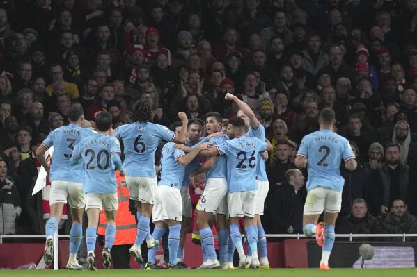 Manchester City players celebrate after Manchester City's Kevin De Bruyne scored his side's opening goal during the English Premier League soccer match between Arsenal and Manchester City at the Emirates stadium in London, England, Wednesday, Feb.15, 2023. (AP Photo/Kin Cheung)