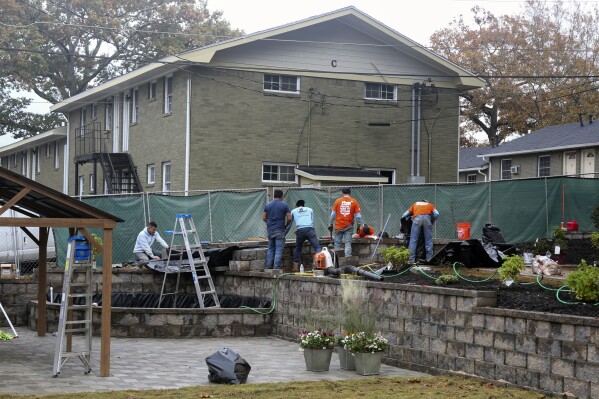 In this photo provided by Gabriella Rico, volunteers from Home Depot work to build a garden and water feature on the campus of the Veterans Empowerment Organization in Atlanta, Nov. 10, 2023. Company employees have volunteered more than 1.5 million hours in service to veterans, including building or repairing 60,000 houses and facilities for former service members. (Gabriella Rico via AP)