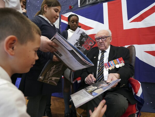 D-Day veteran and Ambassador for the British Normandy Memorial, Ken Hay, 98, who served with the 4th Dorset Regiment, speaks to children during a visit to Rush Green Primary School in Dagenham, England, Monday May 20, 2024, ahead of the 80th anniversary of the D-Day landings. (Gareth Fuller/PA via AP)