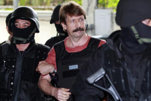 FILE - Viktor Bout, center, is led by armed Thai police commandoes as he arrives at the criminal court in Bangkok, Thailand, Tuesday, Oct. 5, 2010. The Russian arms dealer who once inspired a Hollywood movie is back in the headlines with speculation around a return to Moscow in a prisoner exchange for U.S. WBNA star Brittney Griner and former U.S. Marine Paul Whelan. (AP Photo/Apichart Weerawong, File)