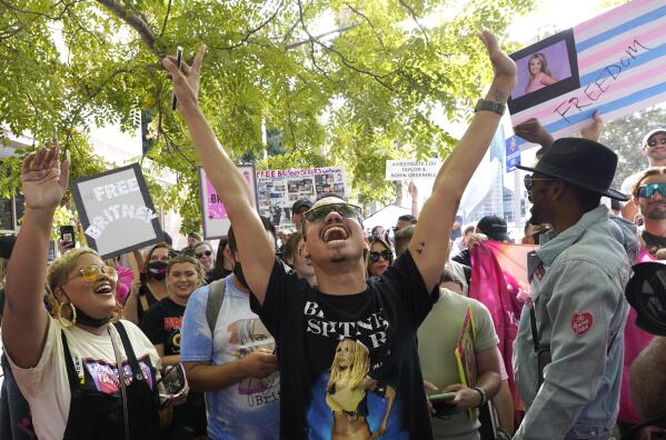 Britney Spears supporter Brian Molina of Los Angeles celebrates outside the Stanley Mosk Courthouse, Wednesday, Sept. 29, 2021, in Los Angeles. A judge on Wednesday suspended Britney Spears' father from the conservatorship that has controlled the singer's life and money for 13 years, saying the arrangement "reflects a toxic environment." (AP Photo/Chris Pizzello)