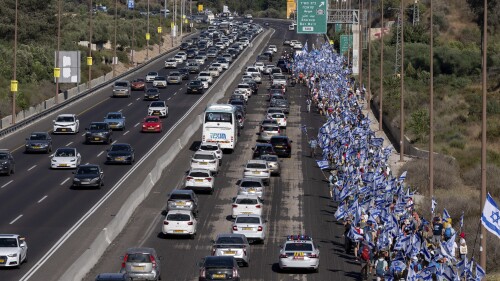 Israelis march along Highway 1 on their way to Jerusalem near Moshav Shoresh in Israel, as part of protests against plans by Prime Minister Benjamin Netanyahu's government to overhaul the judicial system, Friday, July 21, 2023. The protest march from Tel Aviv to Jerusalem is growing as Netanyahu vows to forge ahead on the controversial overhaul. Protest organizers planned to camp overnight at Shoresh, before making their way to Israel's parliament on Saturday. (AP Photo/Ohad Zwigenberg)