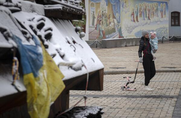 A woman walks past a display of destroyed Russian tanks and armoured vehicles after a snowfall in downtown Kyiv, Ukraine, Thursday, Nov. 17, 2022. (AP Photo/Andrew Kravchenko)