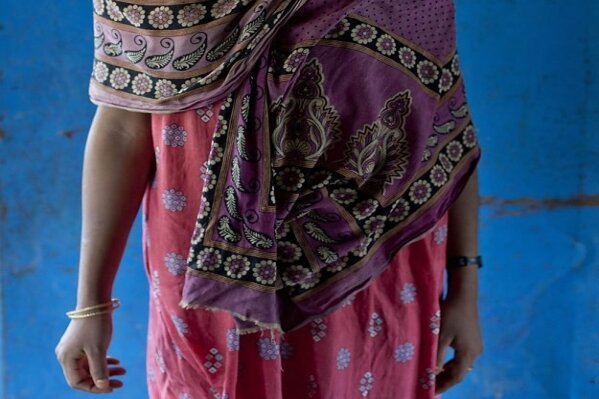 In this Oct. 1, 2017, photo, survivor of a boat capsize Fatima Khatun, from Myanmar's Moidaung Village, stands for a photograph at a transit shelter at Kutupalong camp for newly arrived Rohingya refugees in Bangladesh. Fatima lost her mother and two siblings when the boat they were traveling in, to escape from Myanmar, capsized on Sept. 28. She survived along with her father Lalu Mia and two other siblings. (AP Photo/Gemunu Amarasinghe)