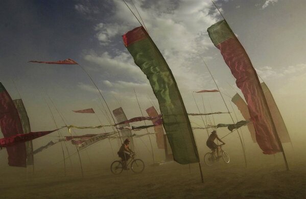  Bicyclists make their way through an art installation at the Burning Man counter-culture arts festival, Wednesday, Sept. 1, 2004, in Gerlach, Nev. (Scott Sady/The Reno Gazette-Journal via AP)
