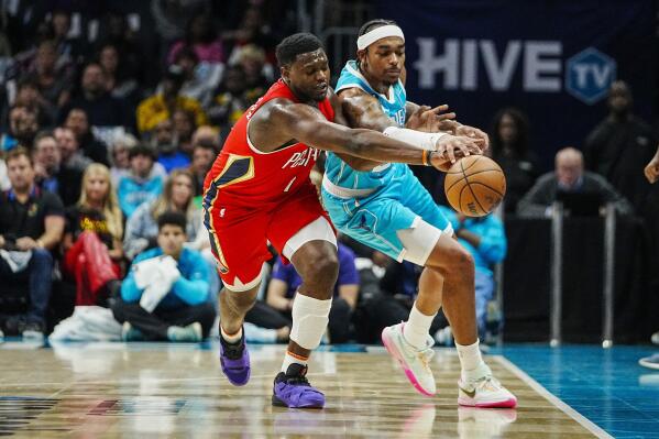 New Orleans Pelicans forward Zion Williamson, left, and Charlotte Hornets forward P.J. Washington reach for the ball during the first half of an NBA basketball game Friday, Oct. 21, 2022, in Charlotte, N.C. (AP Photo/Rusty Jones)