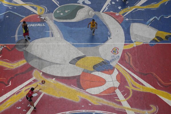 Players run on a court painted with JIP, the FIBA Basketball World Cup mascot, Thursday, Aug. 17, 2023, in Taguig city Philippines. (AP Photo/Aaron Favila)