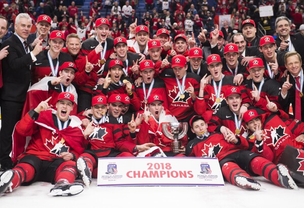 FILE - Team Canada poses for a photo after winning the gold medal with a 3-1 win over Sweden in the third period of the IIHF World Junior Hockey Championship title game on Friday, January 5, 2018 in Buffalo, New York. Players on Canada's 2018 World Junior Team have been placed on leave from their respective clubs in recent days following reports that five members of the team have been asked to turn themselves in to police over sexual assault charges. New Jersey's Michael McLeod and Cal Foote, Philadelphia's Carter Hart, Calgary's Dillon Dube and former NHL player Alex Formenton have been granted indefinite leave and were announced as unavailable this week.  (Nathan Dennett/Canadian Press, via AP, File)