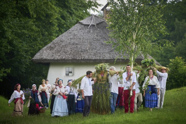People perform a rite during a traditional midsummer celebration in Pyrohiv, Ukraine, outside of Kyiv, Saturday, June 21, 2025. (AP Photo/Efrem Lukatsky)
