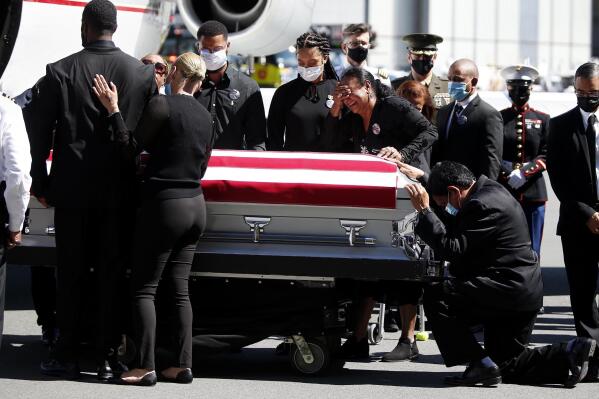 Family members of U.S. Marine Sgt. Johanny Rosario Pichardo are emotional as the casket with Pichardo arrives at Logan Airport on Saturday, Sept. 11, 2021.  Pichardo died in the Aug. 26 suicide bombing near the Kabul airport where people were being evacuated amid the Taliban takeover of Afghanistan.  (Jonathan Wiggs /The Boston Globe via AP, Pool)
