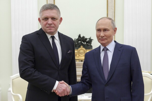 Russian President Vladimir Putin, right, and Slovak Prime Minister Robert Fico shake hands during their meeting at the Kremlin in Moscow, Russia, Sunday, Dec. 22, 2024. (Gavriil Grigorov, Sputnik, Kremlin Pool Photo via AP)
