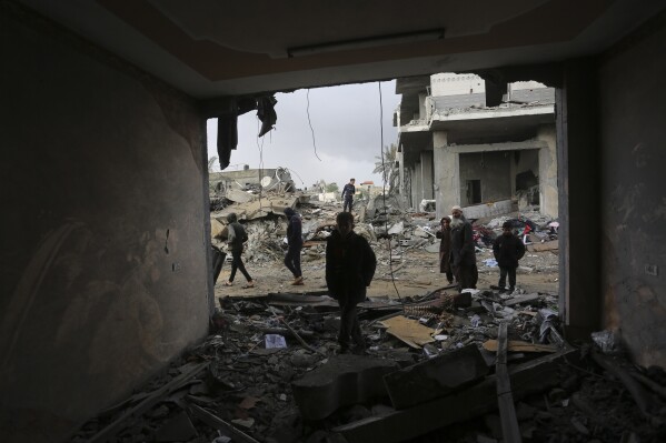 Palestinians look at houses destroyed in the Israeli bombardment of the Gaza Strip in Rafah on Monday, Nov. 20, 2023. (AP Photo/Hatem Ali)