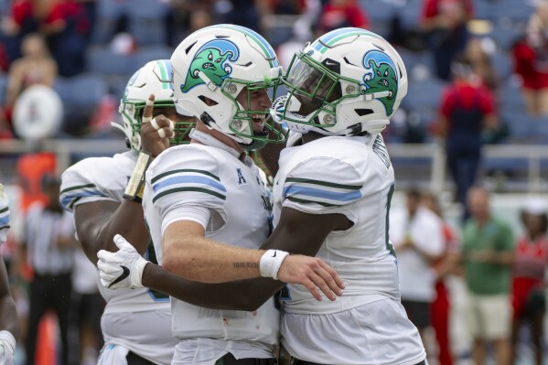 Tulane tight end Chris Carter (11) celebrates with quarterback Michael Pratt (7) after scoring a touchdown during the first half of an NCAA football game against Florida Atlantic, Saturday, Nov. 18, 2023 in Boca Raton, Fla. (AP Photo/Doug Murray)