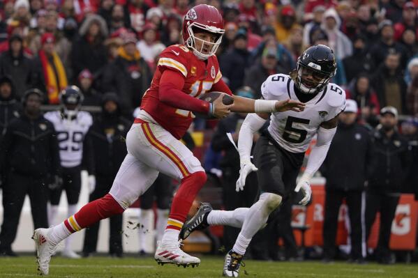 Kansas City Chiefs quarterback Patrick Mahomes (15) runs out of the pocket as Jacksonville Jaguars safety Andre Cisco (5) defends during the first half of an NFL divisional round playoff football game, Saturday, Jan. 21, 2023, in Kansas City, Mo. Mahomes was injured after the play. (AP Photo/Ed Zurga)